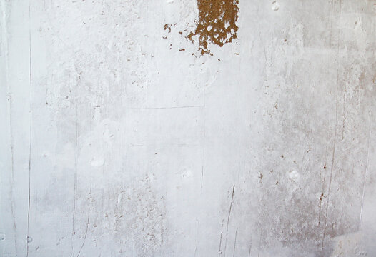 Close-up of construction wall with layered plaster and filler marks. Textured appearance reflects repair work and interior maintenance.