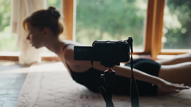 Woman vlogging yoga practice at home