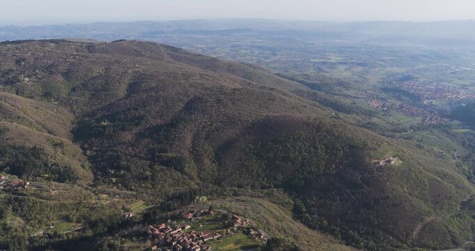 Aerial view of the small village of Trappola nestled among the dense forests and rolling green hills of the Pratomagno mountain range Trappola, Tuscany, Italy.