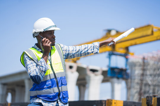 Professional worker in safety gear managing logistics at railway construction