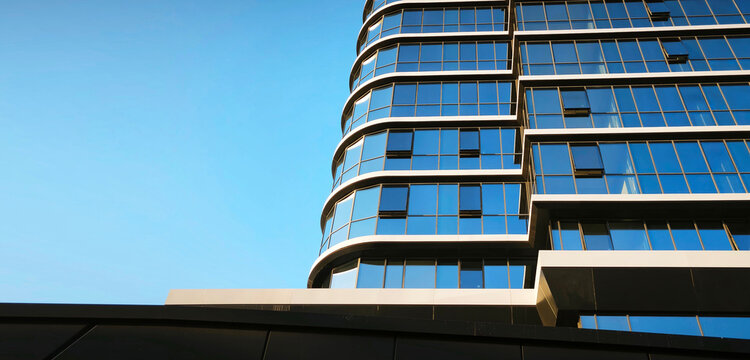 Multi-storey eco-friendly house. Glass facades, economical housing. Minimalist architectural background with blue sky copy space