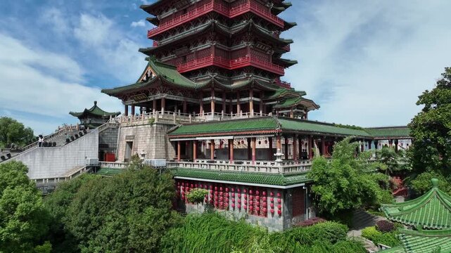 Sky aerial drone view of Tengwang Pavilion rising on the Nanchang riverbank, historic multi story pagoda blending traditional Chinese architecture with a modern skyline, aerial view on a sunny day