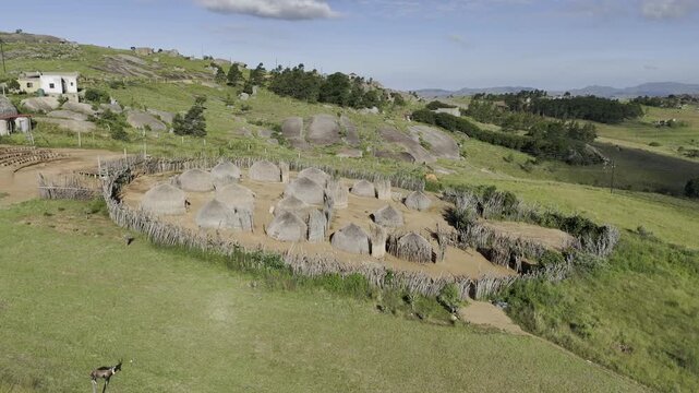 Drone orbits left on west side of Swazi traditional cultural village on late afternoon at Sibebe Rock near Mbabane, Eswatini