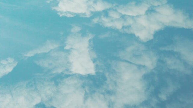 4K white fluffy clouds and pure blue sky, air plane window view, aerial view, slow motion, time lapse. Beautiful azure skyscraper atmosphere and cumulus white clouds, blue sky white cloud background.