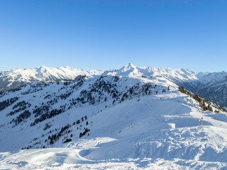 Fototapeta premium Winter Wonderland: Snow-Covered Alpine Landscape with Ski Trails