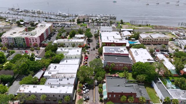 Aerial view of boats docked in marina contrasting with colorful buildings and roads, creating a vibrant scene, Fernandina Beach, Florida, United States.