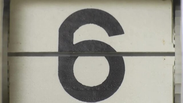 Number 6 displayed on a textured white surface with a horizontal dividing line, close-up view