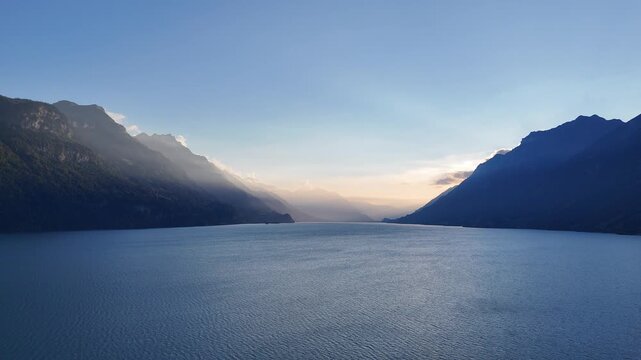 Drone flight video beautiful sunset over lake in Switzerland, blue lake in the evening, stunning sunset.