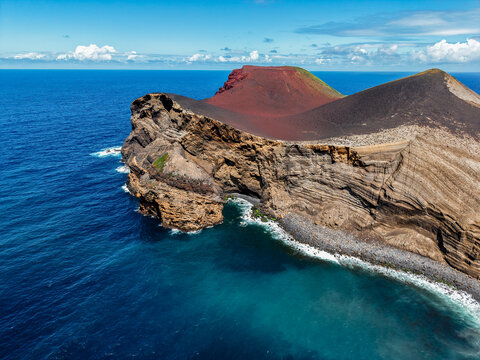 Aerial view of the rugged coastline meets the deep blue sea, where the volcanic landscape rises dramatically, Capelo, Acores, Portugal.