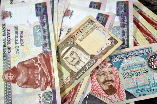 collection of currency banknotes, featuring Egyptian Pounds and Saudi Arabian Riyals, 200 Egyptian Pound note prominently and various denominations of Saudi Arabian Riyals 20 Riyal and 1 Riyal notes