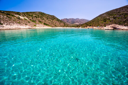 Clear turquoise water covering a serene sandy beach on poliegos island in kyklades, greece