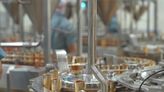 High-speed automated canning production line in a modern manufacturing facility with industrial machinery filling and processing metal cans on a conveyor.