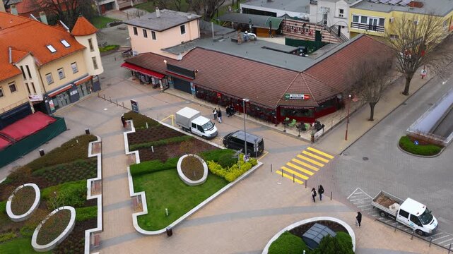 siofok central square viewed from the tower with tiled roofs, pedestrian areas, landscaped zones and light‑colored buildings forming an organized urban layout