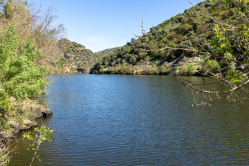 Obraz premium Dam creating reservoir in green valley landscape