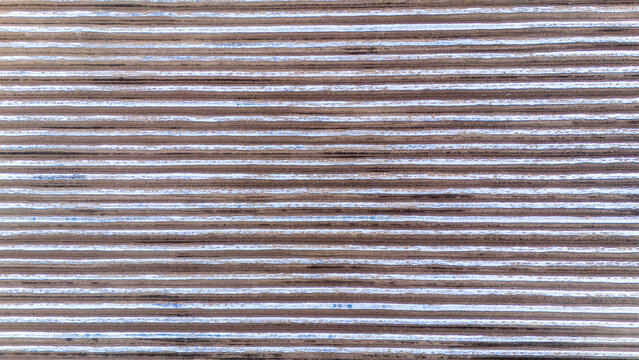 Aerial view of parallel lines stretching across the landscape, creating a textured pattern of light and shadow, Kovilj, Vojvodina, Serbia.