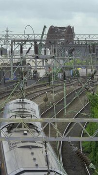 Passenger Train on Mainline Approach with HS2 Curzon Street Viaduct Construction, Birmingham, UK.
An elevated view from a bridge showing a modern passenger train navigating a curved mainline track.
