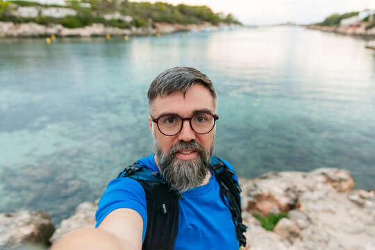 Man taking selfie enjoying coastal trail running in menorca