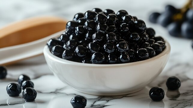Dark, glistening black tapioca pearls in a small white bowl