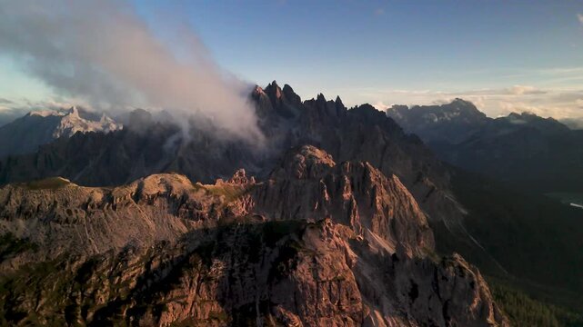 The famous insta spot of Cadini di Misurina at sunrise in the Sexten Dolomites. The clouds hang low in the morning light. An idyllic morning amidst the mountains of South Tyrol.