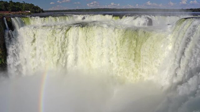 Powerful Iguazu Falls waterfall in Argentina, breathtaking footage of Devil's Throat with mist and rainbow in the tropical jungle