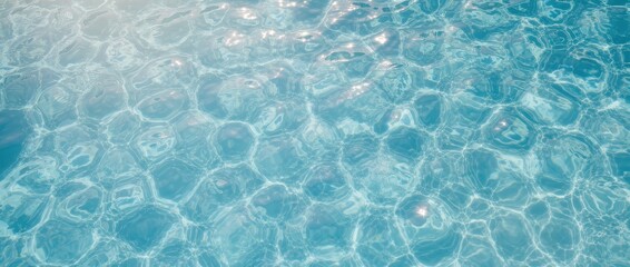 Obraz premium Overhead view of clear turquoise water with sunlight reflecting on the surface creating sparkling caustic patterns.