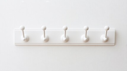 Obraz premium White coat rack with five hooks against a bright wall background