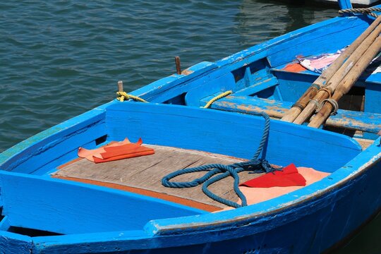 Blue traditional fishing boat in Mediterranean harbor of Bari, Italy.