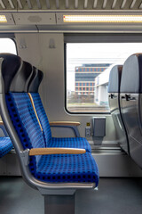 Obraz premium empty train compartment with blue seats and window showing building through blurred motion, modern design