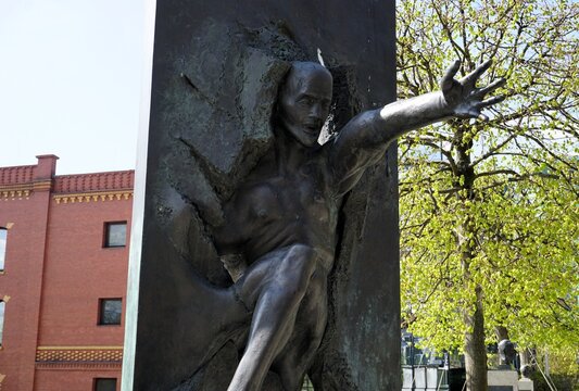 The sculpture "Wir sind das Volk" on Stra&szlig;e der Erinnerung in Berlin-Moabit, Germany, depicts a man bursting through the Berlin Wall.