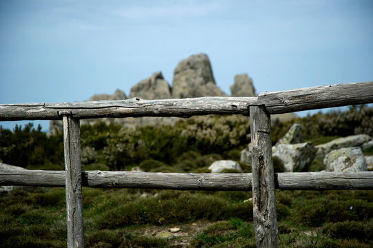 a wooden fence overlooking the rocky landscape of the Mount Limbara near Berchidda in Sardinia, Italy. 
Limbara. Tempio. Pausania