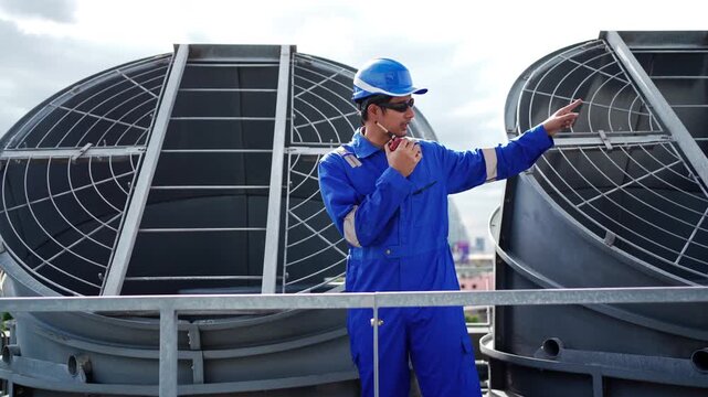 Industrial engineer using walkie-talkie on factory rooftop