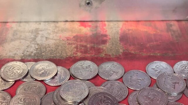 Close up video. Old arcade push machine slot with Georgian metal coins 20 tetri. GEL, lari bill. Concept of cash money, bad luck, bet, bank, gambling in game room, casino, fate, fail, risk, budget