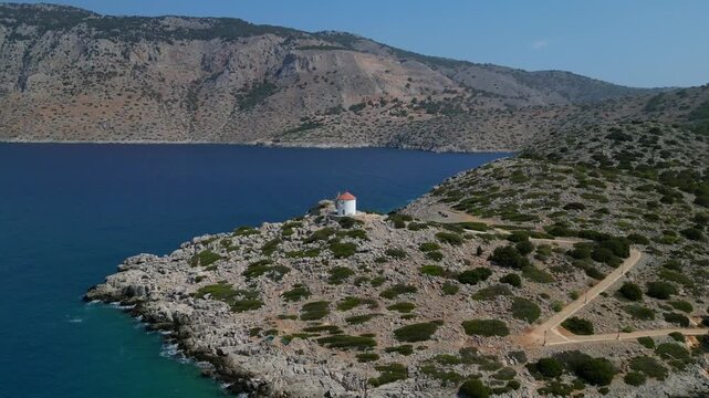 Aerial view of Panormitis Bay with traditional windmill and blue sea, Symi island