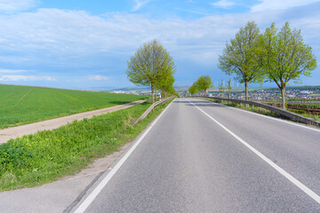 Obraz premium Scenic Road through German Countryside with Wind Turbines and Fields