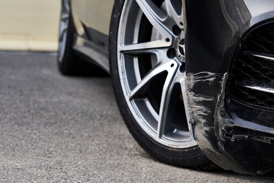 Black bumper car scratched with deep damage to the paint.