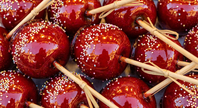 Glossy candy apples on sticks with festive red coating