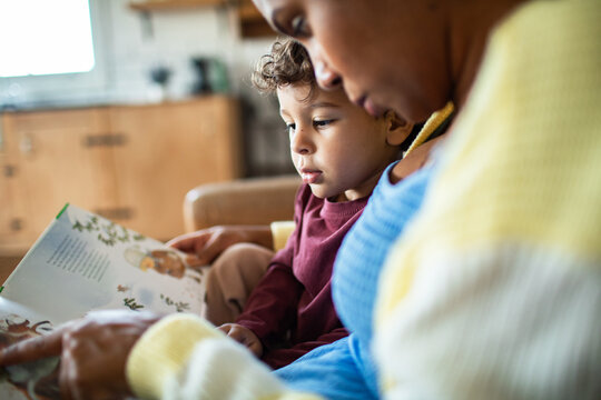 Parent and child reading storybook at home