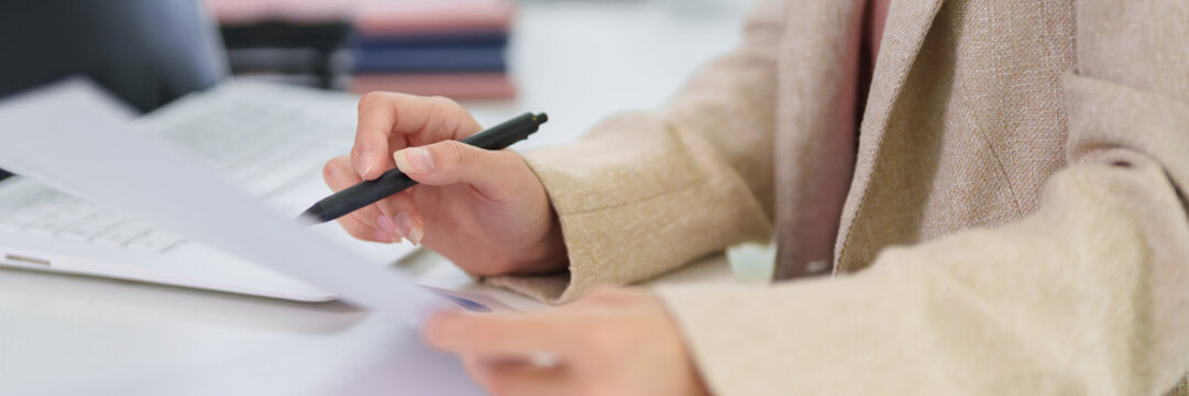 businesswoman hand review financial document report data analysis office desk professional corporate workspace paper pen business meeting preparation strategy planning
