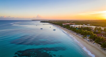 Aerial view of a tropical coastline at sunrise with clear turquoise water, white sand beach, and resorts