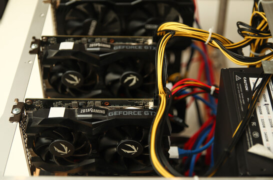 Volodymyr, Ukraine - 03.11.24: graphics cards installed in a computer rig. Professional GPU mining farm for cryptocurrency with yellow and black power cables. Technology and digital hardware concept