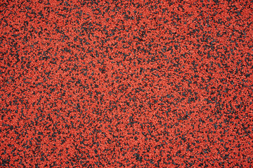 Red and black EPDM rubber crumb surface texture. Seamless shock absorbing floor background for playground or running track.