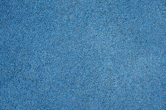 Blue EPDM rubber crumb surface texture. Seamless shock absorbing flooring background for athletic running tracks or playgrounds.