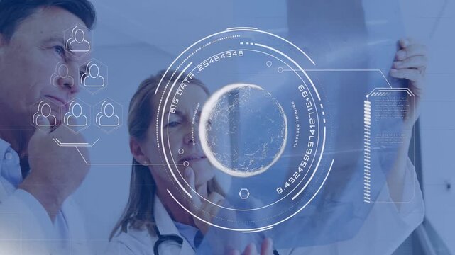 Senior doctor holding X-ray and activating HUD overlaying film, colleague joining, both analyzing