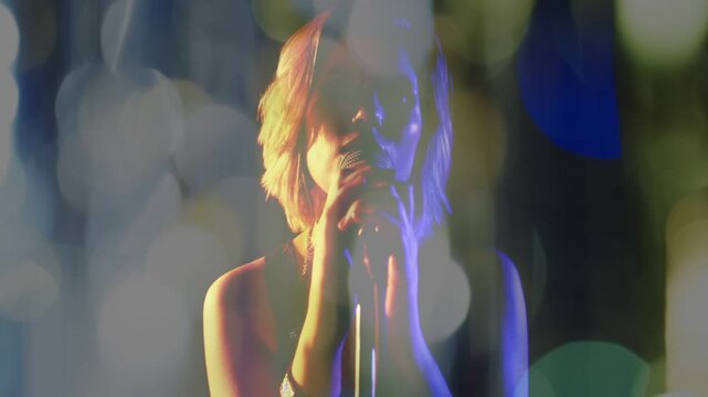 Female teen singer holding mic stand, camera revealing face while singing and bokeh lights shifting