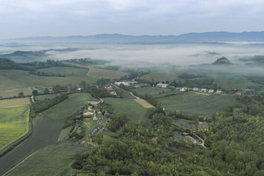 Aerial view of Le Balze del Valdarno with rolling green hills and farmhouses under a thick layer of morning mist Castelfranco Piandisco, Tuscany, Italy.
