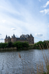 Muiderslot castle in Muiden, the Netherlands, viewed from a distance across the water on a clear day. © Pim