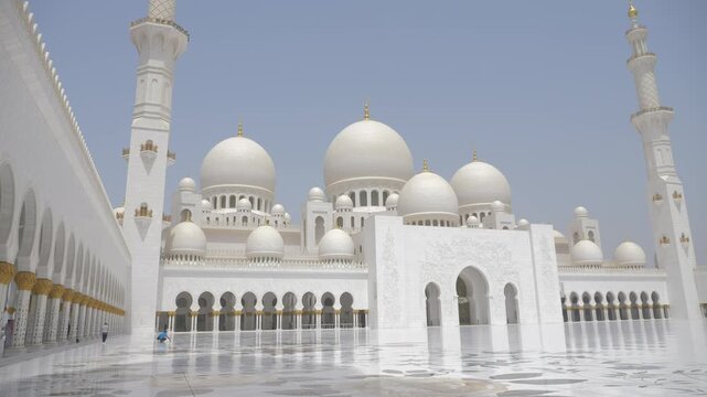 White mosque in Abu Dhabi. Vast marble courtyard surrounded by domes and colonnades