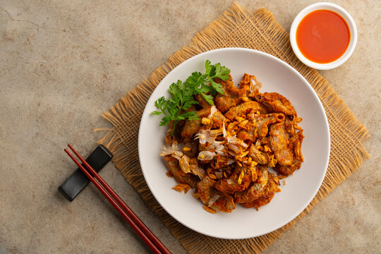 Deep Fried Pork Intestines with Crispy Garlic in white plate.with chilli sauce.Top view.