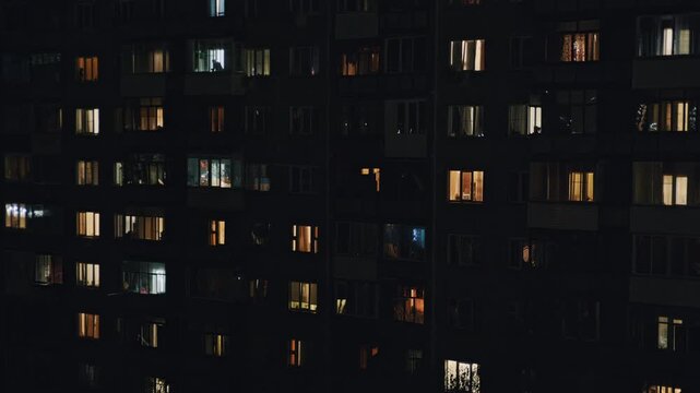 Residential building in Eastern Europe shown in a time lapse from daylight to night and back, with flickering windows emphasizing human activity and time flow