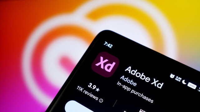 Closeup of a smartphone screen displaying the adobe xd app page in an app store